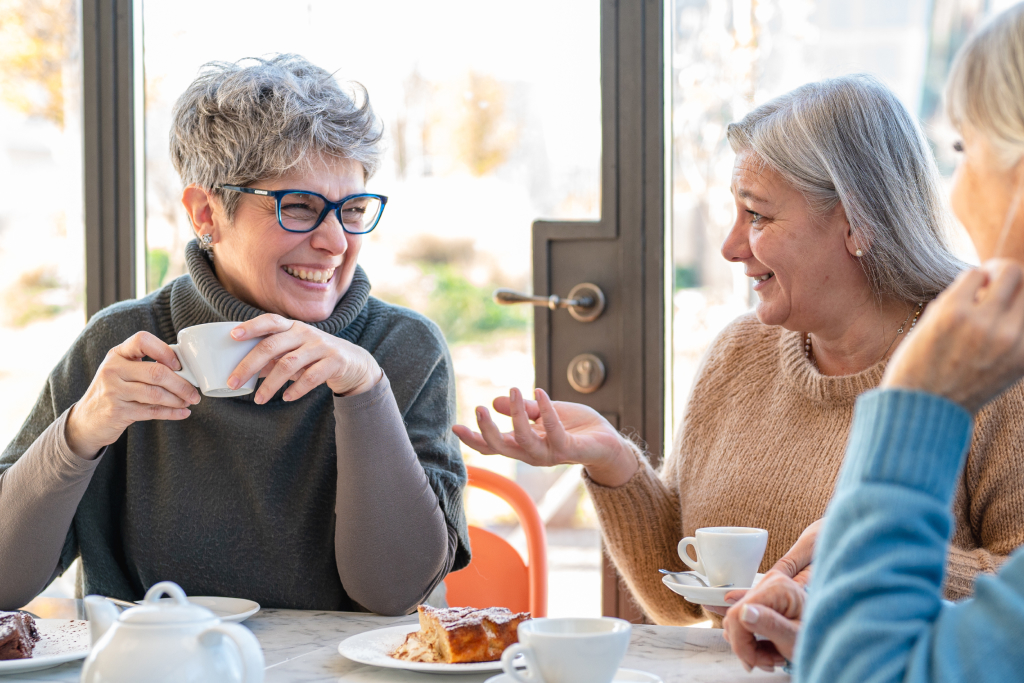 Drei grauhaarige Frauen reden beim Kaffee trinken miteinander